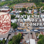 Gráfico de Ciudad Sostenible instando a entender los permisos de construcción antes de comprar propiedades en Nuevo Cuscatlán, ilustrado con una vista aérea de un gran desarrollo inmobiliario en curso dentro de una zona residencial.